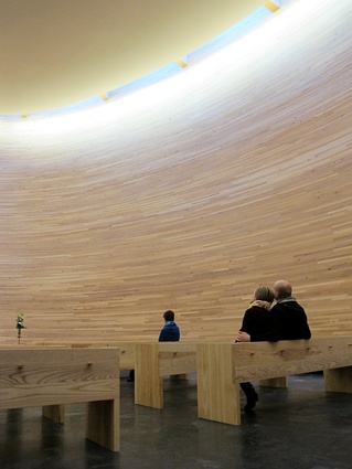 Birch-lined walls envelope the chapel interior in a cone of silence.