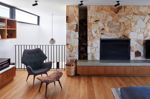 A sandstone feature wall adds nuance to the material palette and continues through both levels of the home.