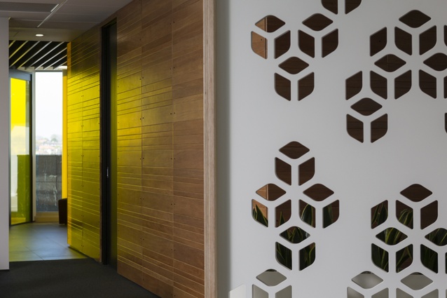 Warm tõtara wall panelling is juxtaposed against the linear ceiling panels and dark tile flooring. 
