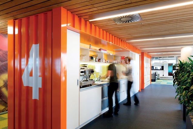 Shipping container kitchenette - a splash of colour. The rough sawn timber ceiling denotes a circulation hub. 
