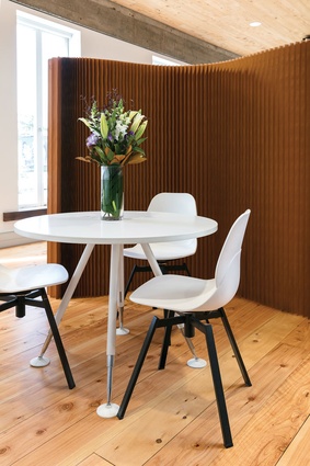 A small meeting area with chairs from Fuse behind a Softwall Kraft Paper screen from Unison Workspace.