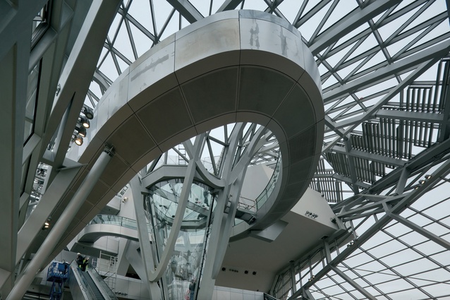 Musée des Confluences, France. Spaces inside are connected by a curving bridge-like structure. A spiralling ramp offers access to the various exhibition spaces.