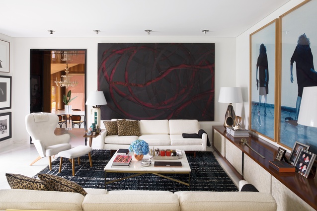 A painting by Aaron Young hangs above one of two white sofas by Milo Baughman.