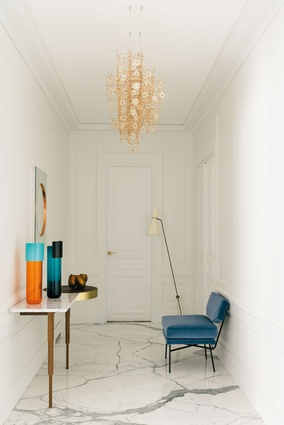 The entry is memorable for its few key pieces of furniture, including lighting by Dandelight by Studio Drift.