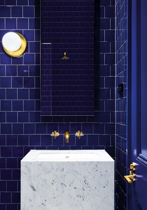 A vivid Victorian blue powder room is one of a series of small interventions in the existing house.
