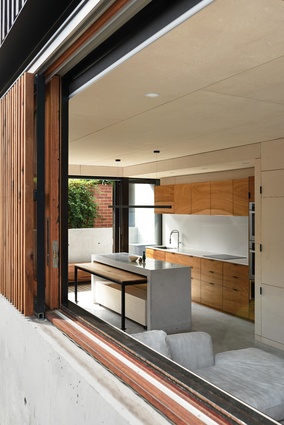 Sliding glass doors beyond the kitchen open to a narrow courtyard that lets in ample daylight.