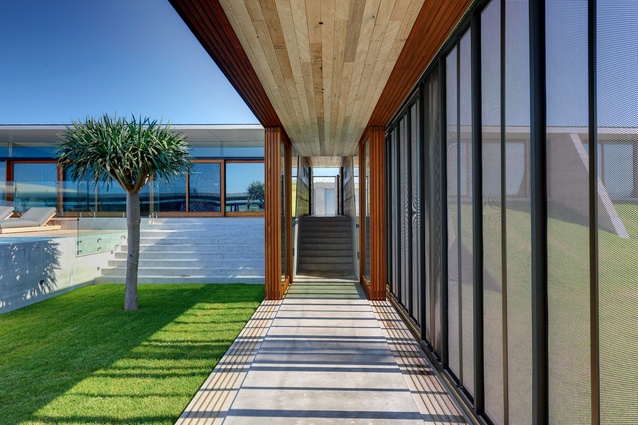 A transparent central breezeway spine links the public zone to the private zone and runs adjacent to the central grassland courtyard and pool.