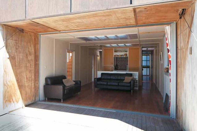 Looking from the deck into the living and kitchen area through open sliding doors. 