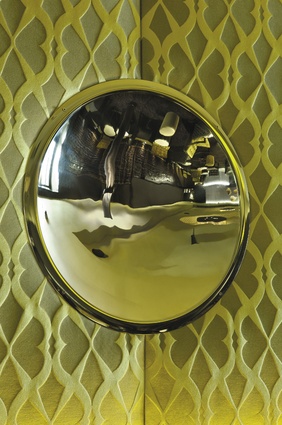 A stainless-steel concave mirror provides a distorted view of the lounge.