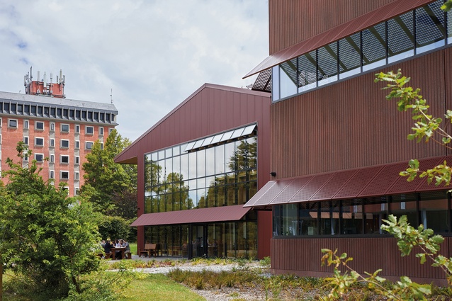 Red pre-cast concrete and red profiled metal cladding differentiate the two wings.