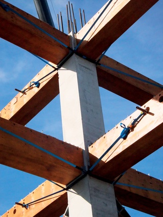 The post tensioned frame structure utilises precast concrete columns and structural laminated veneer lumber beams. 