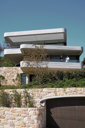 The board-formed concrete structure of the house is expressed in the cantilevered floors, which double as balconies, and exposed on the ceilings.