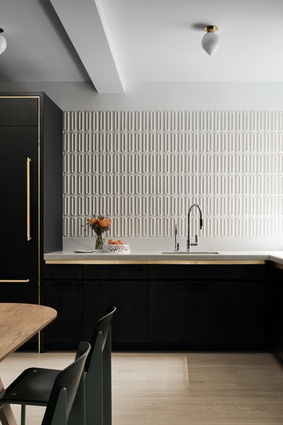 Glossy, moulded tiles by Ann Sacks pick up light in the kitchen.
