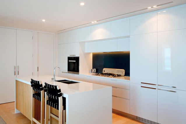 An all-white kitchen layout is packed full of storage, a key criteria for discerning apartment buyers. 
