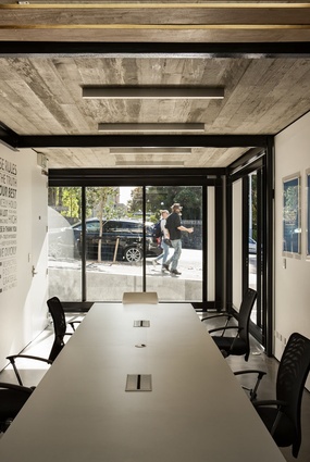 A conference room with low windows purposefully invites the gaze of pedestrians and drivers as a way to interact with the community. 