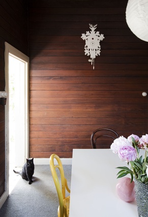 A funky cuckoo clock in the dining room adds interest to traditional timber-lined walls.