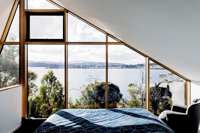 Perched above the living area, the main bedroom captures river views.