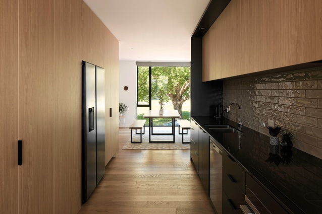 The kitchen is central to the plan, with dining at one end and living at the other.