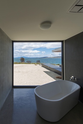 A minimalist bathing space on the house’s west end allows its users to soak in the views.