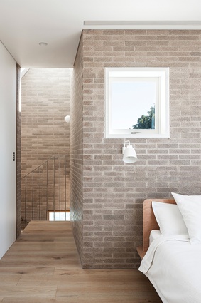 The master bedroom has a calm brick-and-white palette. 