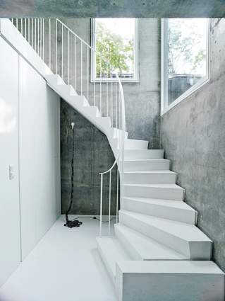 The white concrete stairs add a sculptural element to the overall scheme, complemented by a floor lamp by artist Franz West.