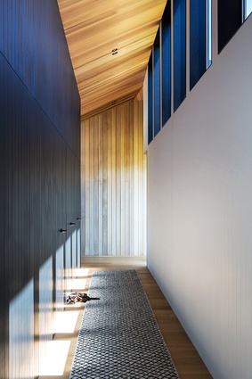 The corridor is clad in dark-stained cedar, tieing in the black hues in the kitchen.