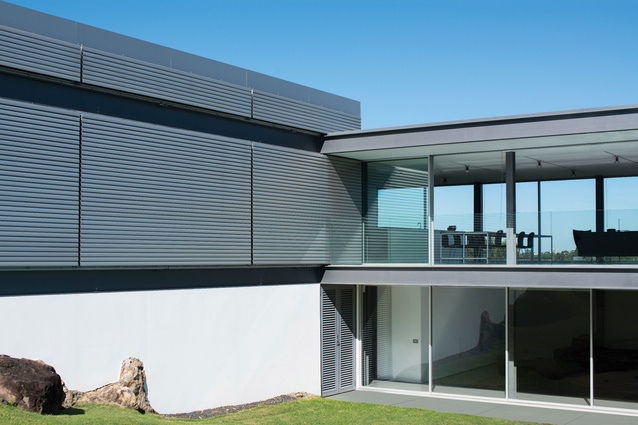 The house was conceived as an “open viewing platform,” with glass and aluminium operable louvres controlling privacy and shading.