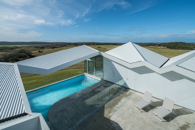 The central courtyard is open to the sky, while the roof folds over the pool as an open canopy.