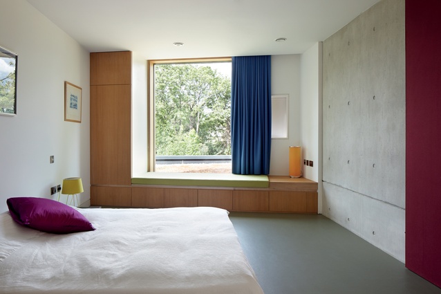 The guest bedroom features a window seat that overlooks the garden.