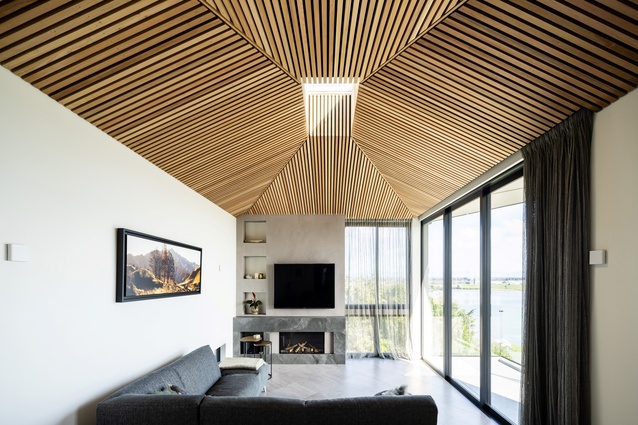 The sculptural timber-battened ceiling reaches upwards to a central skylight.