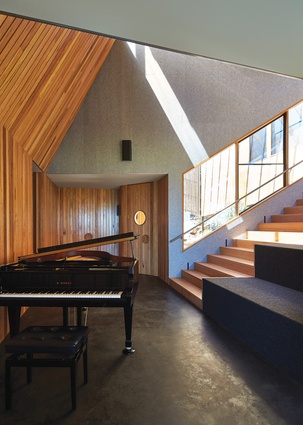 The stair is not only a bridge between the home’s two halves, it’s also an amphitheatre to witness piano performances.
