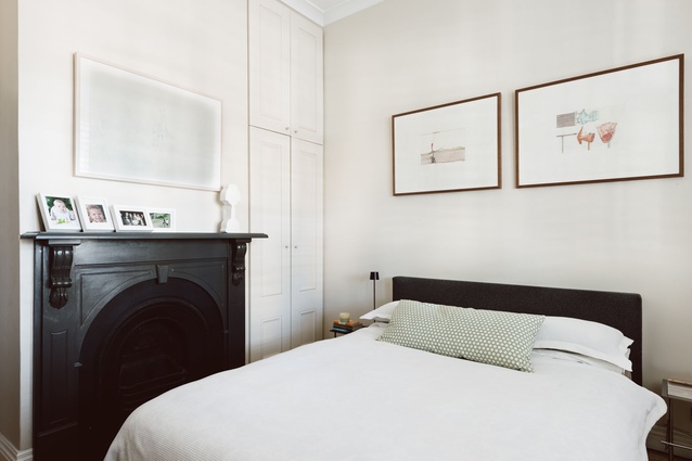 The master bedroom is at the front of the Edwardian terrace house and the black-and-white interiors match those of the newer part of the home. 