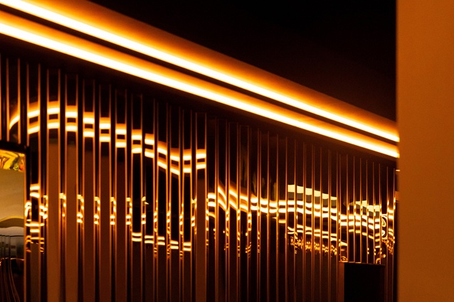 Warm lights interacting with the stainless steel panels, creating playful dimensions. 