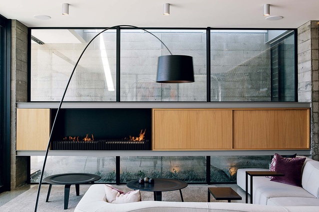 The sitting area, with its sleek fireplace, looks out on the inlet.
