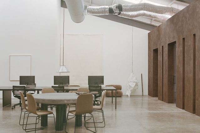 Natural light from the ceilings fills the open central workspace that is incased by the basalt walls.