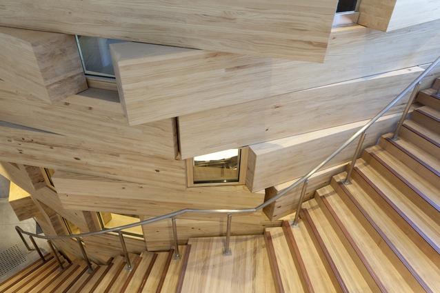 A stairwell wraps around the oval classroom volume.
