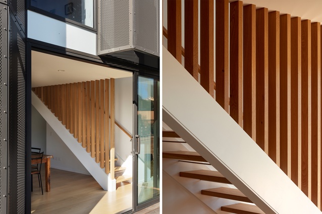 The staircase adds a sculptural backdrop to the dining area, with oak fins that reach to the ceiling. 