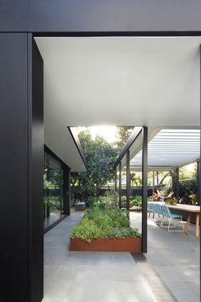 The external dining area is sheltered under a separate pavilion structure from the main living area.