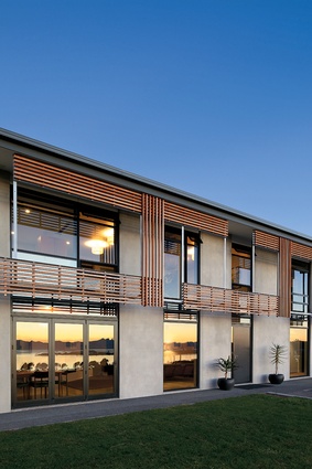 The northwest elevation’s timber sun-shading device softens the massive concrete panels. 
