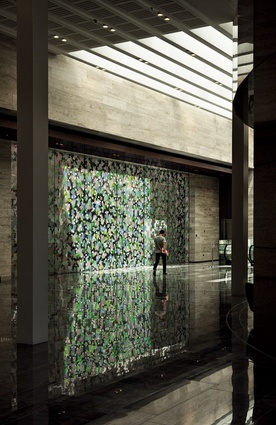 A work by Sara Hughes called Orangery has been applied to both sides of a glass wall which veils a firewall and the perimeter of the building next door.