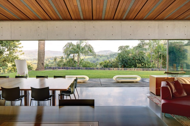The public pavilion opens to a deck by the pool, framing long views to the mountains.