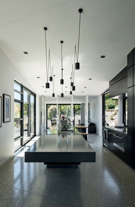 The kitchen lighting was custom-made by the architects using standard light fittings. The kitchen bench is cantilevered concrete.
