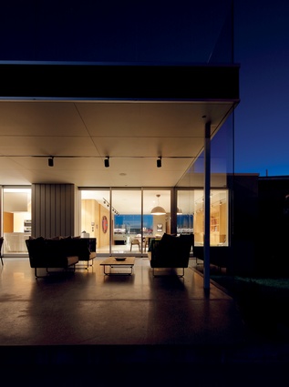Walls of glass in the main living spaces allow generous views across the Manawatu river estuary and the sea beyond. 