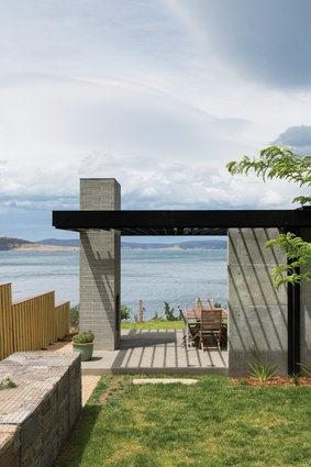 To the north, an outdoor room is framed by a concrete block fireplace and a pergola overhead.