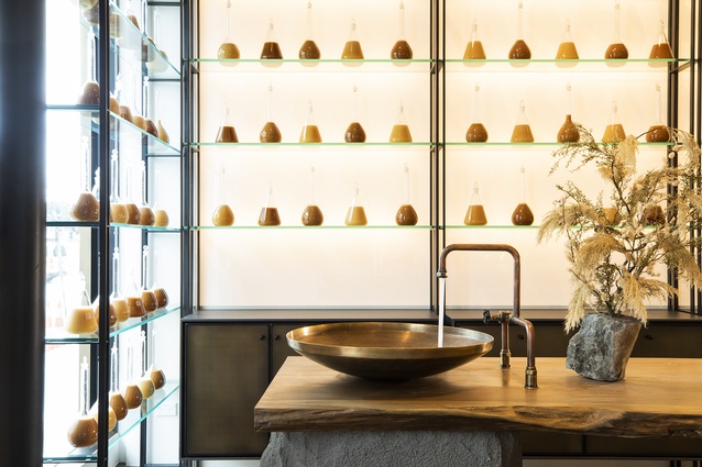 To convey a sense of apothecary, glass lab vessels are filled with honey across a range of colour tones and displayed as a feature wall that wraps to the shopfront.