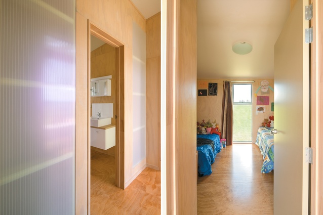 The family bathroom, clad in translucent plastic sheet; the plywood floors and walls are an appropriate backdrop for children’s colourful paraphernalia.
