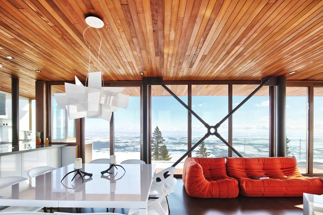 The upper-level sitting area features floor-to-ceiling windows and doors. 