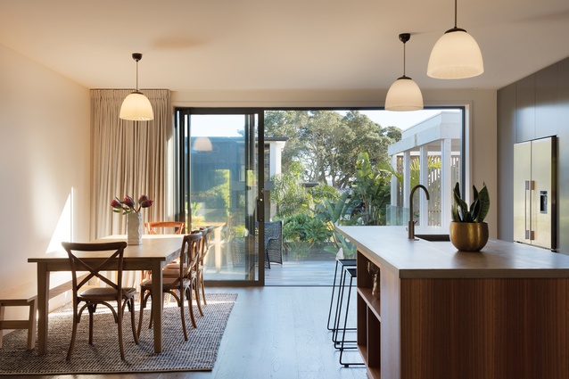 Verso Architecture + Interiors reconfigured the layout of this home by removing a cluster of walls on the upper floor and creating an intimate yet open kitchen and dining space.