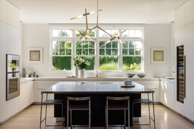 The custom Boffi kitchen features a Lindsey Adelman Agnes light fixture, a Corian back counter and a marble kitchen island top. The paintings on either side of the window are by Josef Albers.