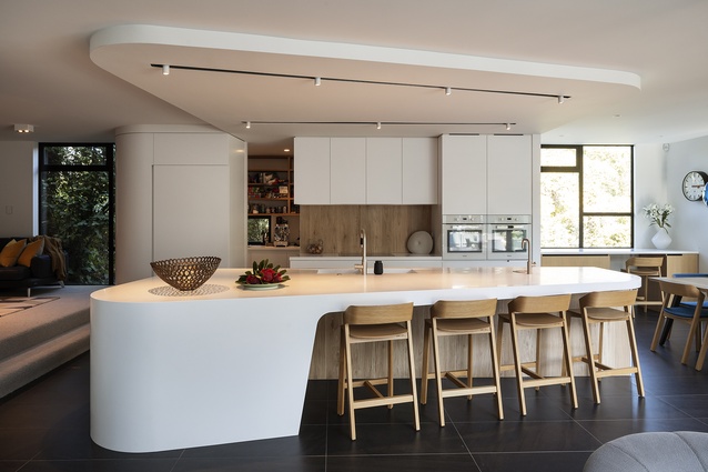 Featuring white corners that smooth out the more boxy parts of the house, the kitchen is intended to serve as a hub for the lounge.